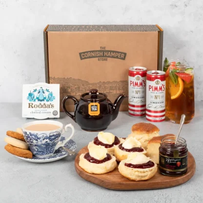 Cornish Cream Tea Hamper with Pimm’s, served on a wooden plate beside a teapot and two full glasses of Pimm’s