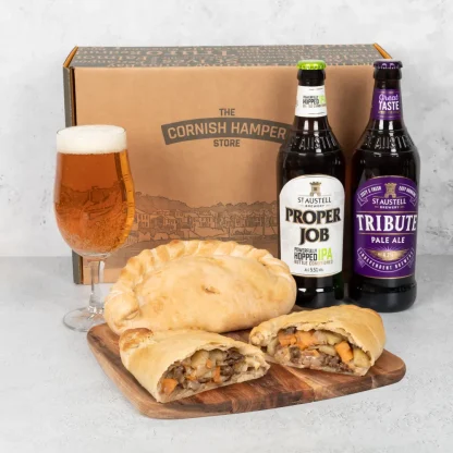 Two freshy baked Cornish Pasties rest beside a bottle of Tribute Pale Ale and a bottle of Proper Job