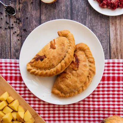 Cornish pasties on a plate surrounded by ingredients