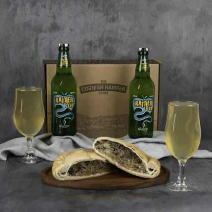 Giant Traditional Steak Pasty served and sliced in half beside two glasses of alcohol free cider