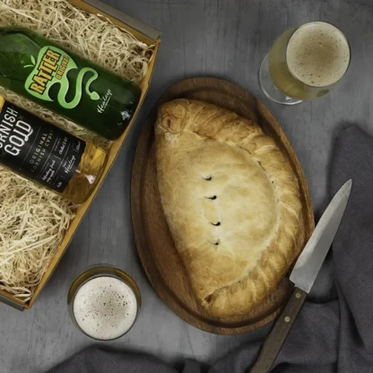 Giant pasty with bottles of Cornish cider served as a gift for dad to enjoy