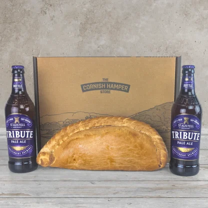 Giant Cornish Pasty surrounded by two bottles Tribute Pale Ale and a Cornish Hamper Store box