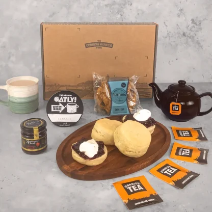 Dairy free vegan food gift hamper displayed on wooden serving board. The vegan scones have been topped with jam and oat fraiche