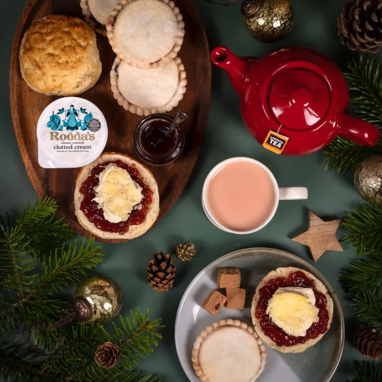 The Gluten Free Christmas Cream Tea Hamper Gift featuring scones topped with strawberry jam and Rodda's classic clotted cream