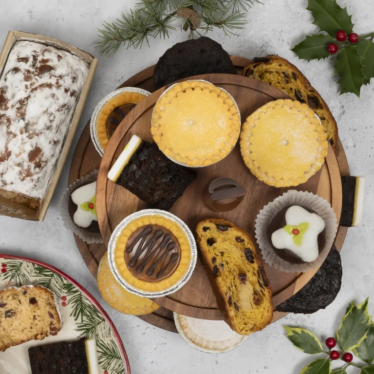 Close up cornish christmas mince pies, sliced stollen, chocolate truffles and congress tarts