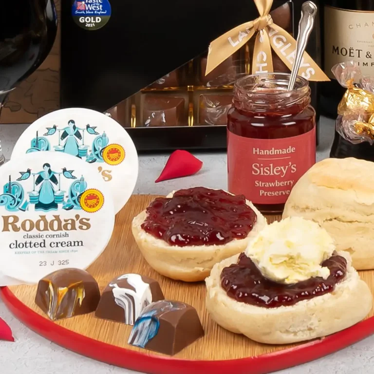 Roddas classic cornish clotted cream and sisleys handmade strawberry preserve spread on to freshly baked cornish scones