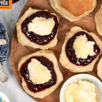 Freshly baked scones topped with jam and clotted cream