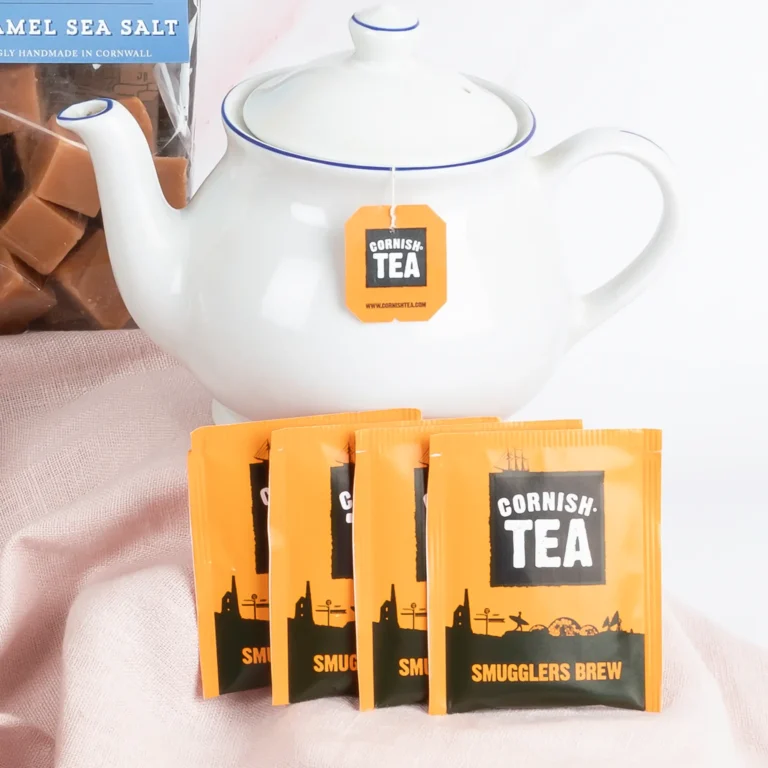A white Cornish teapot beside smugglers brew tea bags and buttermilk fudge